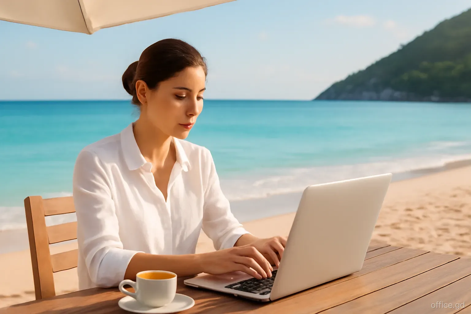 Entrepreneur on a laptop at a shaded beachfront table near Morne Rouge, coffee and notebook beside her, turquoise water behind, three-quarter view, soft late-afternoon light